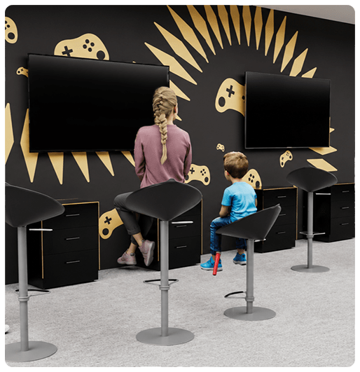 image: Woman and boy sitting in front of televisions in gaming zone